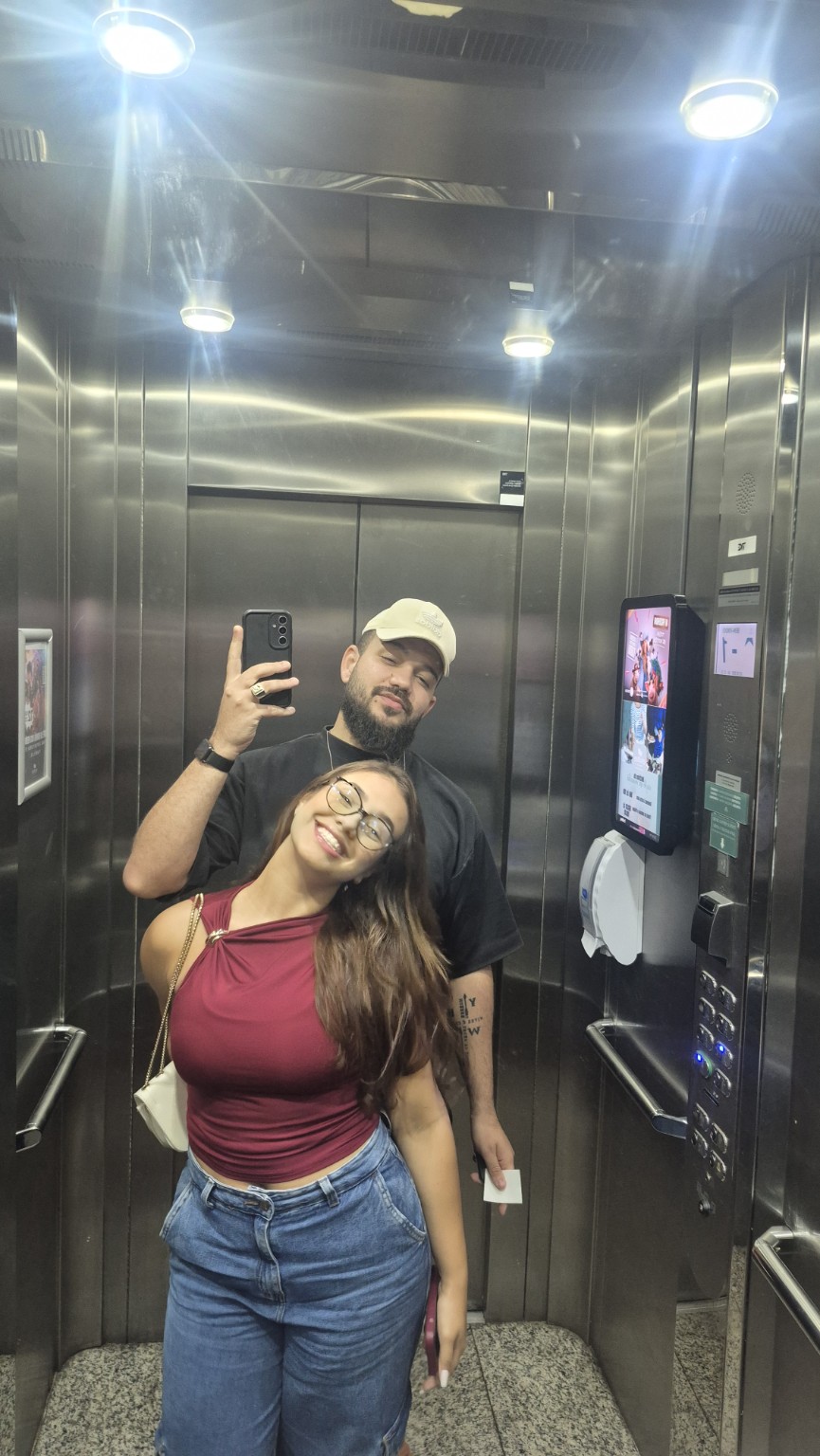 Foto do casal no espelho de um elevador